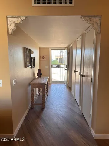 a hallway with wooden floor windows and chairs