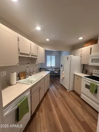 a kitchen with a sink a refrigerator and white cabinets