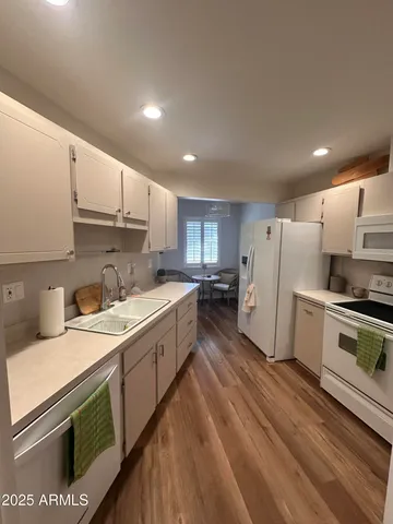a kitchen with a sink a refrigerator and white cabinets