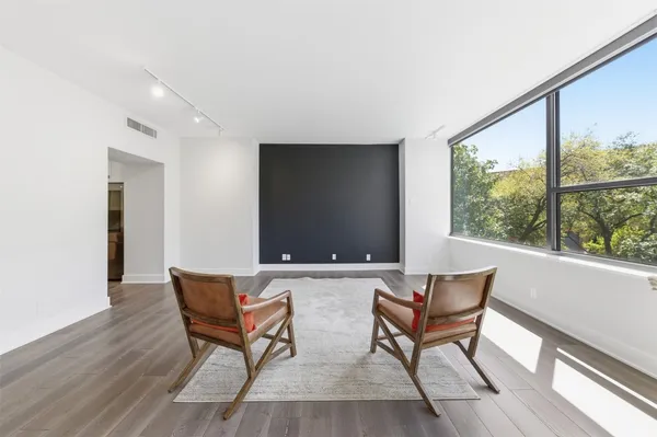 a view of a living room and dining room with furniture window and wooden floor