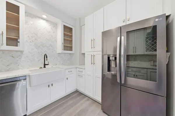 a kitchen with a refrigerator sink and cabinets