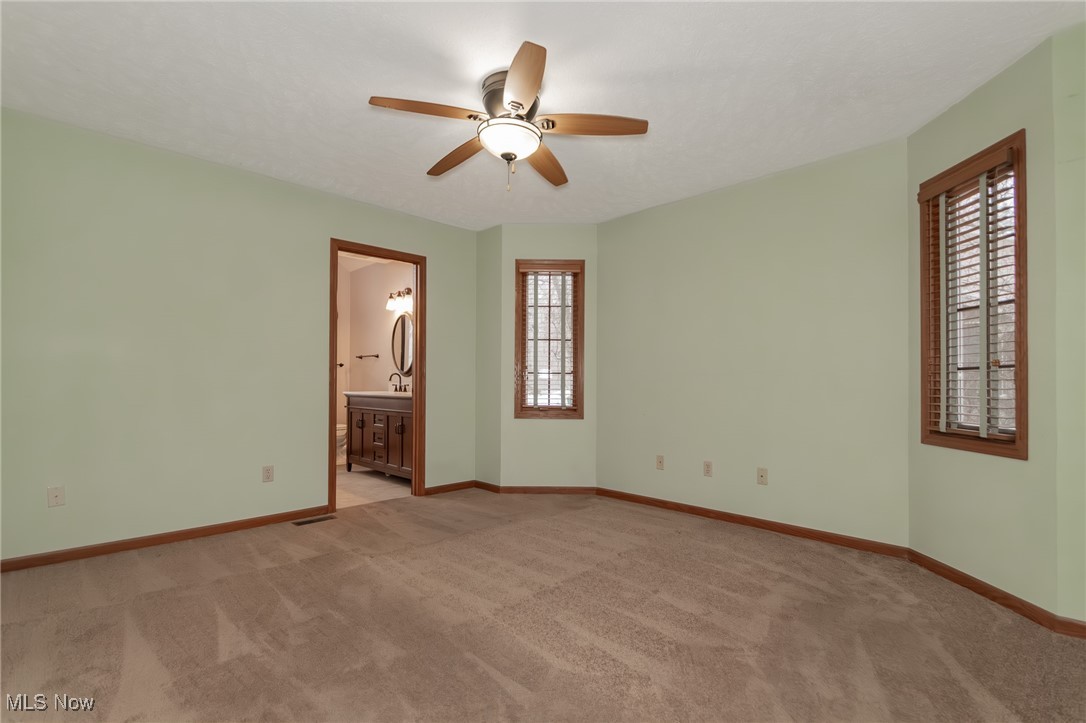 4815 South Ridge Road Perry, OH 44081 - Photo 21 of 48 Unfurnished bedroom featuring a ceiling fan, light carpet, and connected bathroom