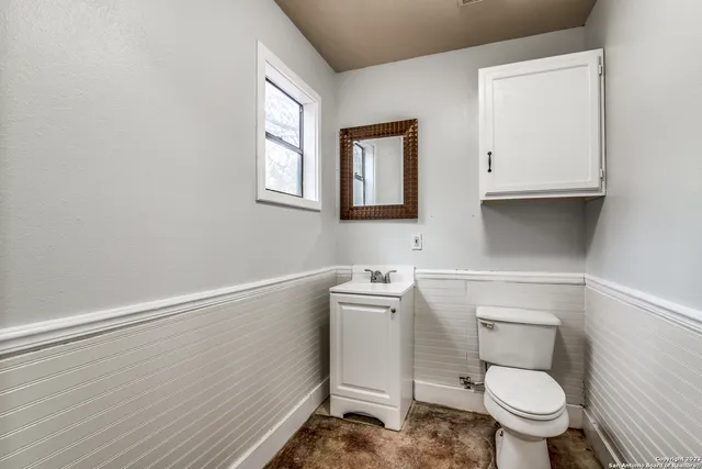 a bathroom with a toilet a sink and a window