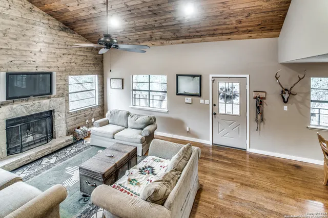 a living room with furniture a flat screen tv and a fireplace