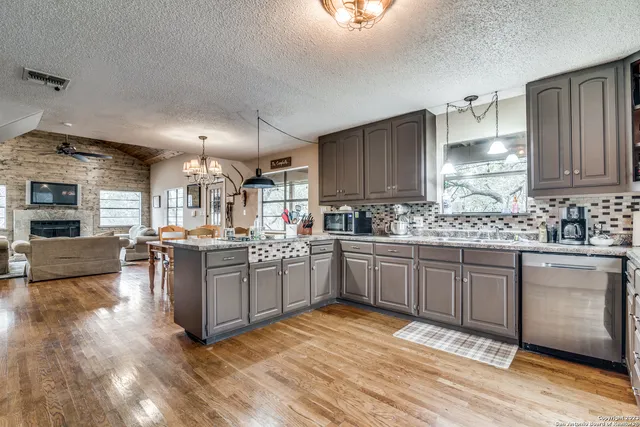 a kitchen with stainless steel appliances granite countertop a stove a sink dishwasher and a refrigerator