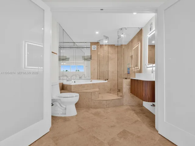 a bathroom with a bathtub shower sink mirror and toilet