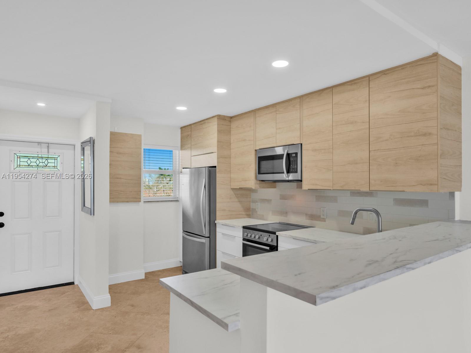 750 Northeast Spanish River Boulevard, Unit 5050 Boca Raton, FL 33431 - Photo 4 of 41 a kitchen with stainless steel appliances a refrigerator sink and microwave