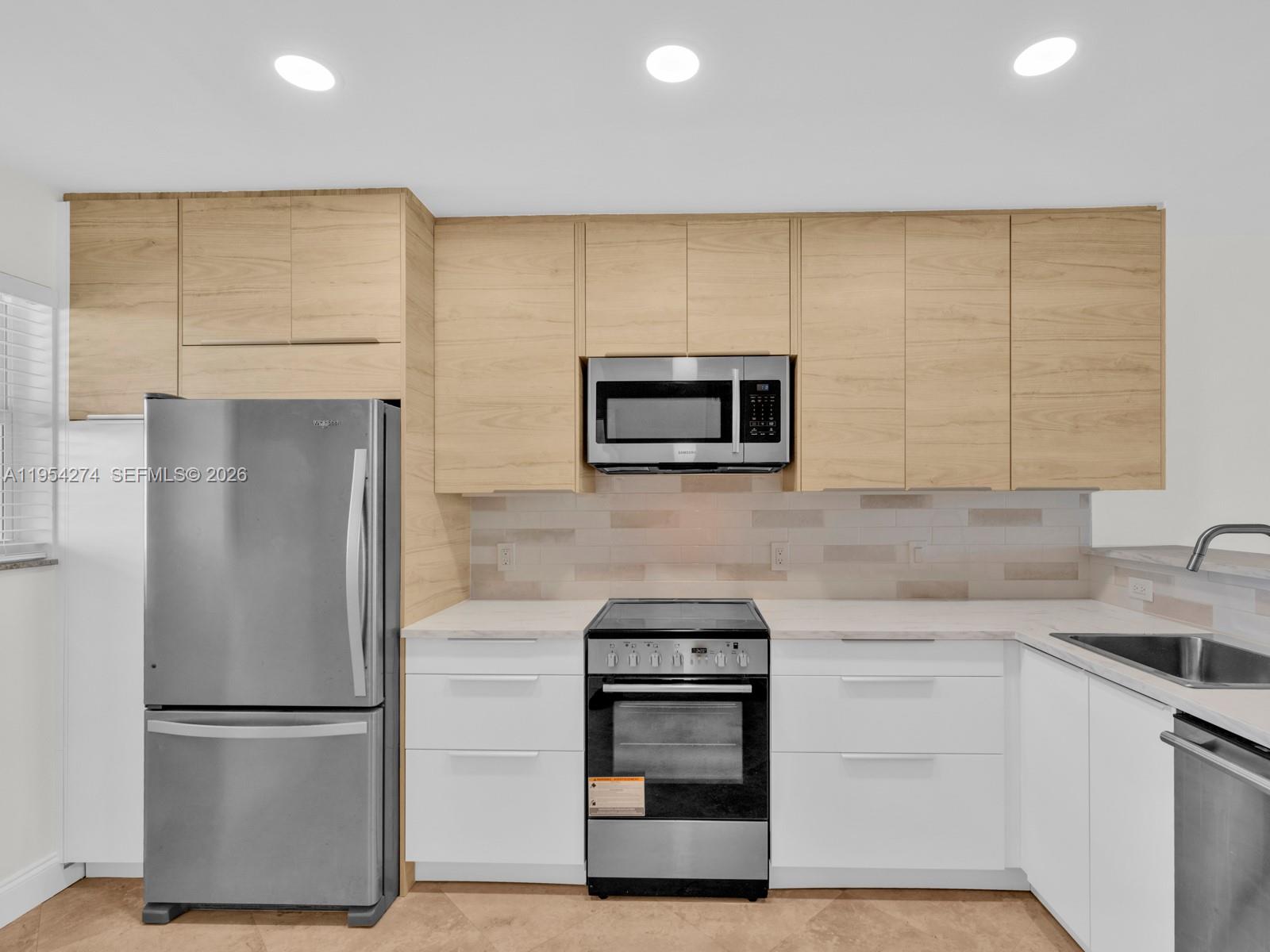 750 Northeast Spanish River Boulevard, Unit 5050 Boca Raton, FL 33431 - Photo 5 of 41 a kitchen with stainless steel appliances a refrigerator sink and microwave