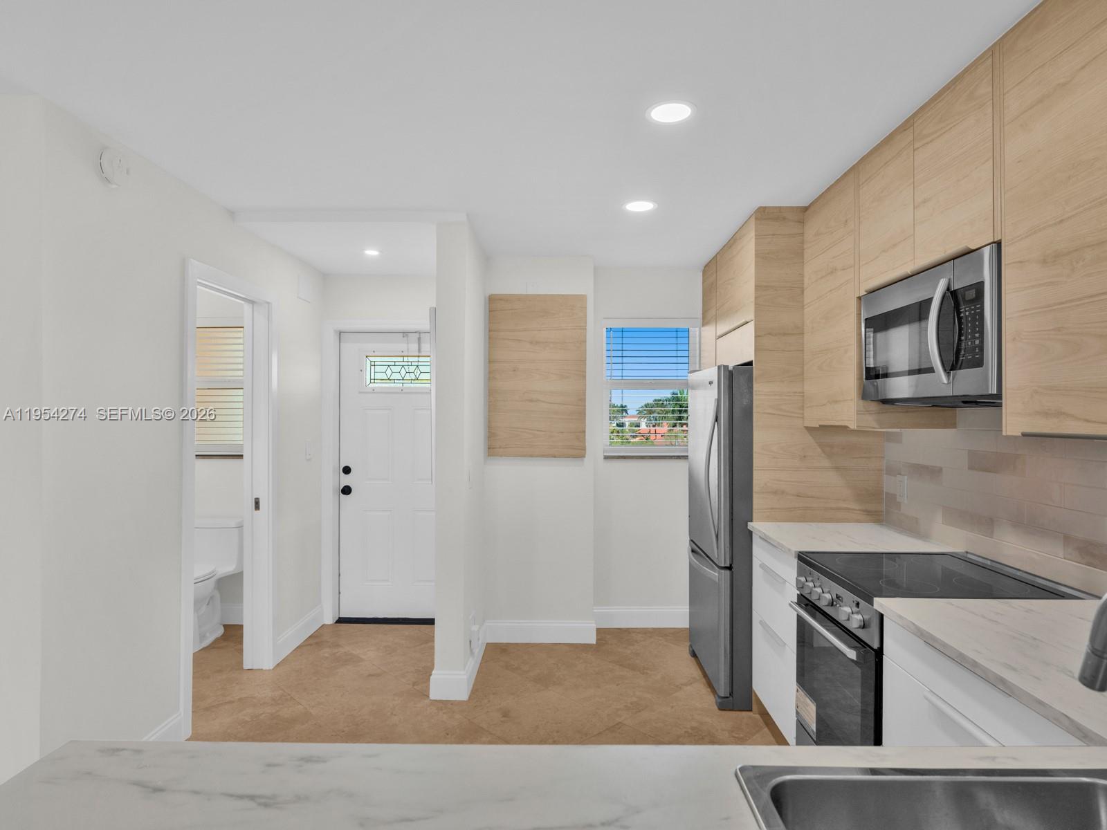 750 Northeast Spanish River Boulevard, Unit 5050 Boca Raton, FL 33431 - Photo 7 of 41 a kitchen with stainless steel appliances granite countertop a refrigerator and a stove top oven