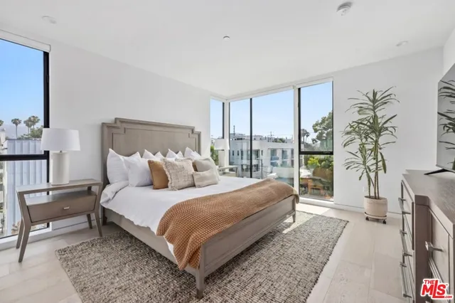a bedroom with furniture and a large window