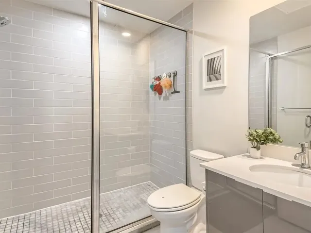 a bathroom with a shower a toilet and a sink