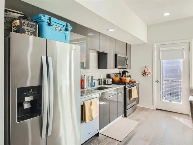a kitchen with stainless steel appliances a refrigerator sink and microwave