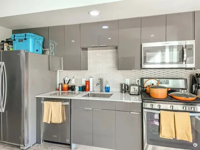 a kitchen with stainless steel appliances granite countertop a sink and a refrigerator