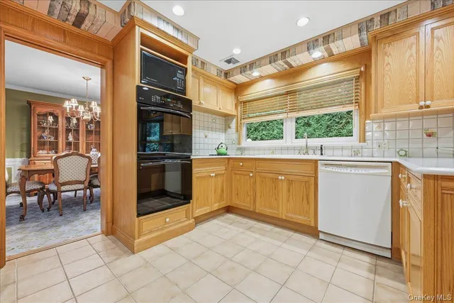 a kitchen with a stove a sink and white cabinets
