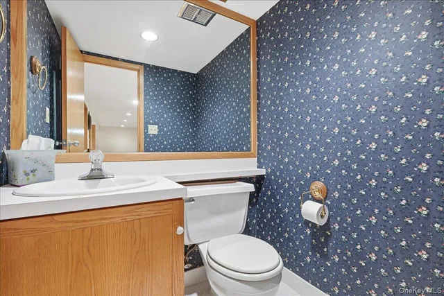 a bathroom with a toilet a sink and mirror