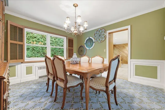 a view of a dining room with furniture a chandelier and wooden floor