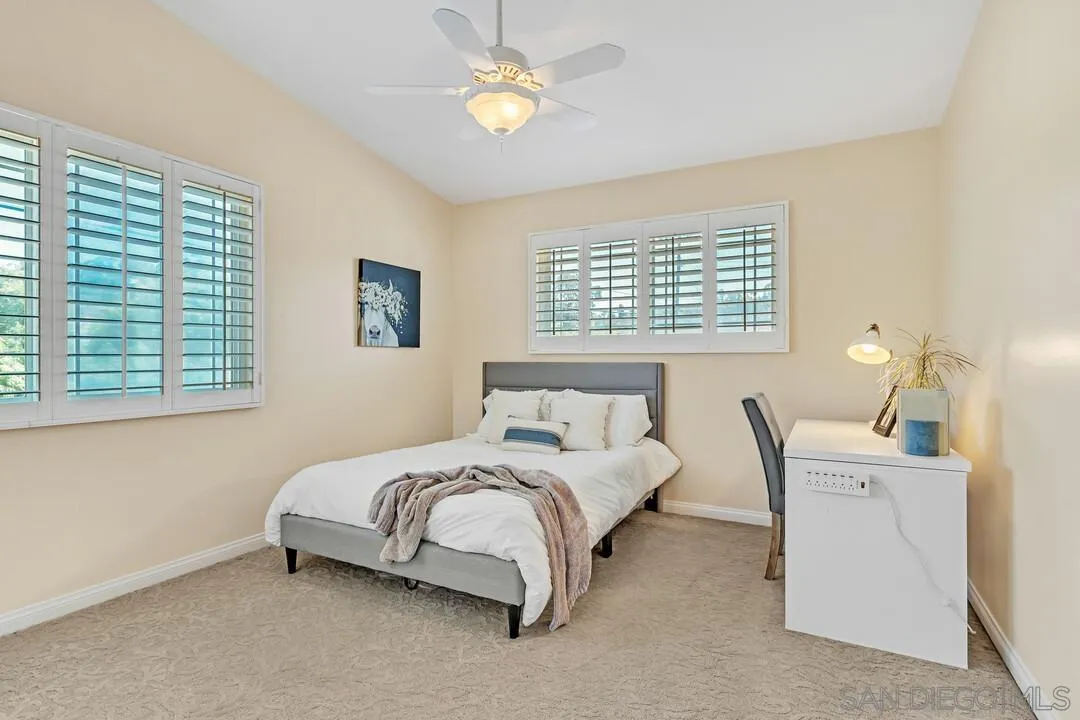 14228 Frame Road Poway, CA 92064 - Photo 28 of 49 a spacious bedroom with a bed and a chandelier