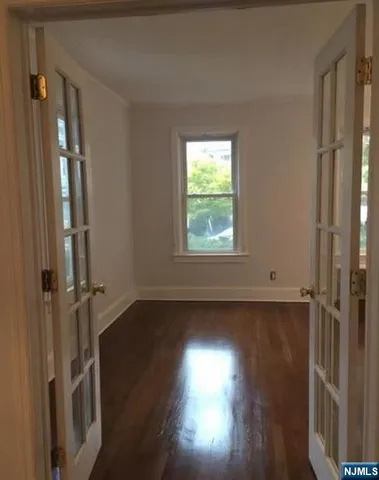 a view of a room with wooden floor and a window