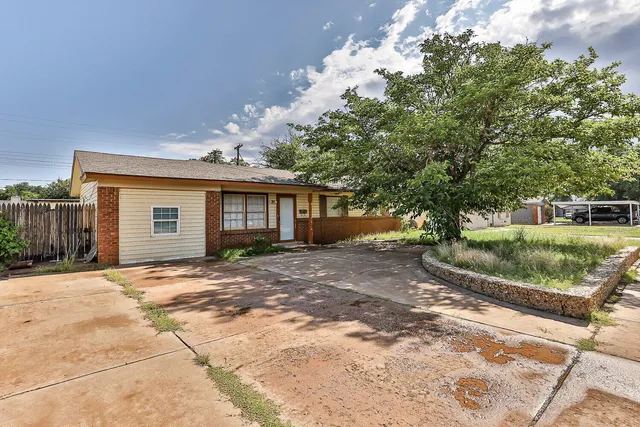 a view of a house with a tree in front of it