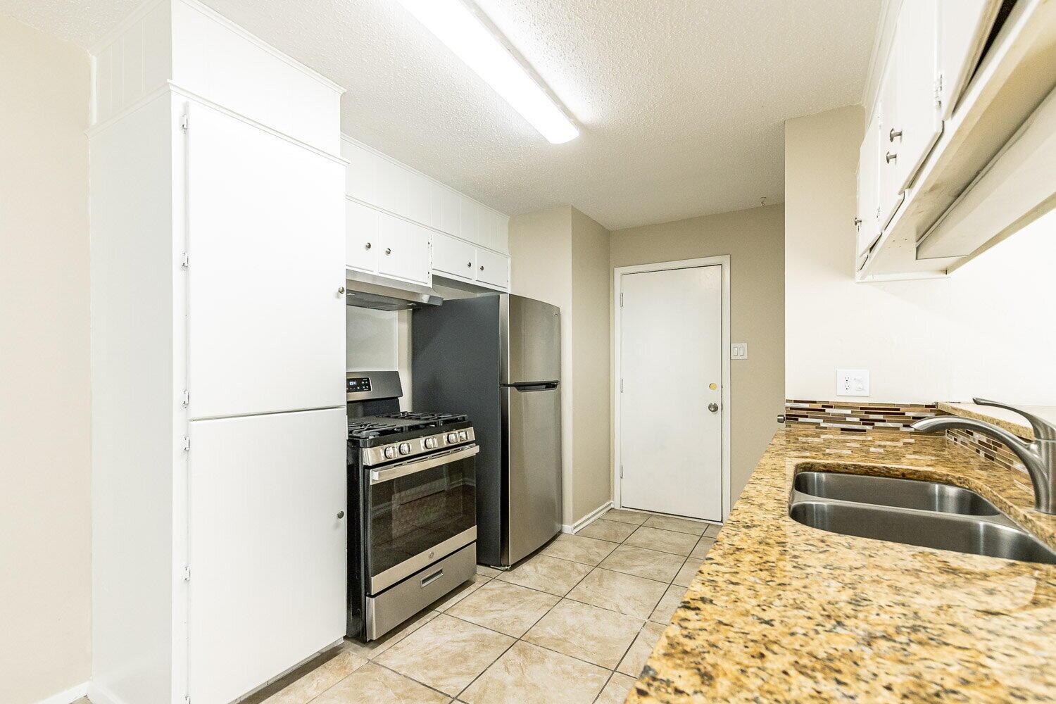 1916 71st Street Lubbock, TX 79412 - Photo 4 of 10 a view of a kitchen with a sink and refrigerator