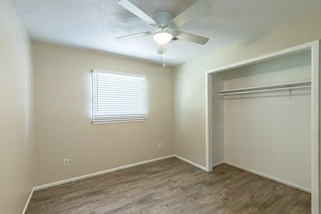 an empty room with fan and windows