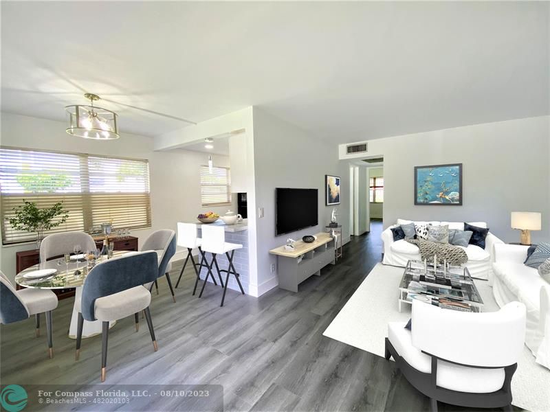 211 Mansfield East, Unit 211 Boca Raton, FL 33434 - Photo 1 of 14 a living room with furniture a flat screen tv and a large window