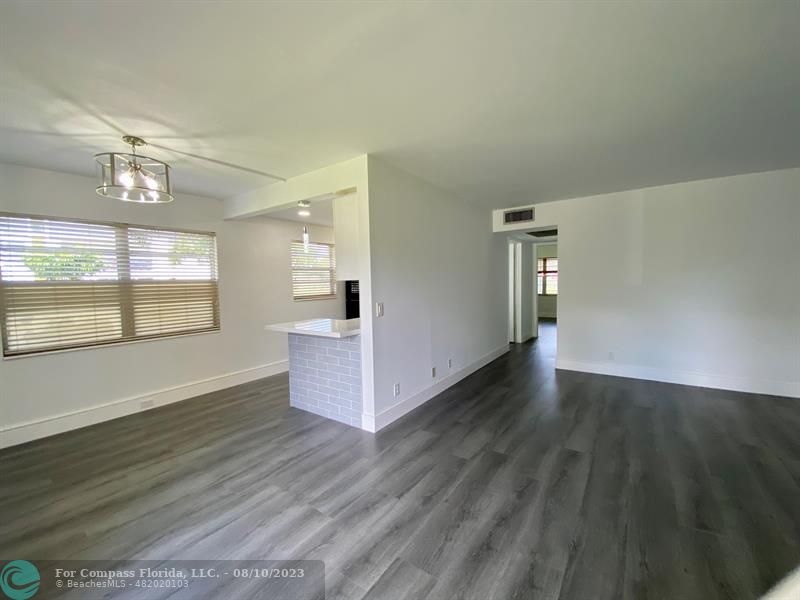 211 Mansfield East, Unit 211 Boca Raton, FL 33434 - Photo 11 of 14 an empty room with wooden floor and windows