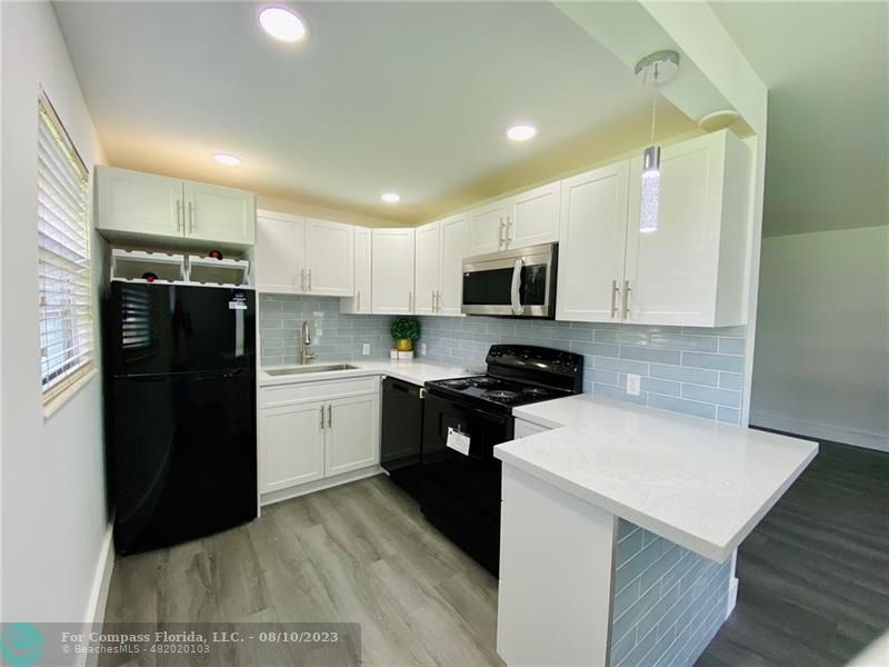 211 Mansfield East, Unit 211 Boca Raton, FL 33434 - Photo 2 of 14 a kitchen with a refrigerator a stove top oven a sink and dishwasher