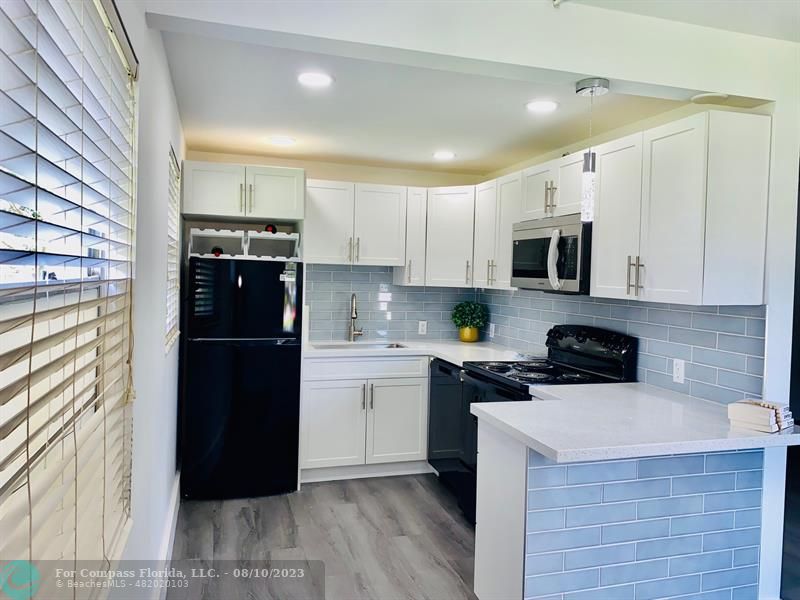 211 Mansfield East, Unit 211 Boca Raton, FL 33434 - Photo 3 of 14 a kitchen with stainless steel appliances a refrigerator sink and microwave