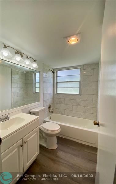 211 Mansfield East, Unit 211 Boca Raton, FL 33434 - Photo 5 of 14 a bathroom with a double vanity sink a toilet a mirror and shower