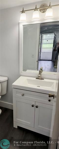 211 Mansfield East, Unit 211 Boca Raton, FL 33434 - Photo 6 of 14 a bathroom with a sink a toilet and mirror