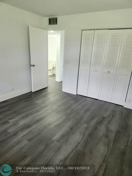 211 Mansfield East, Unit 211 Boca Raton, FL 33434 - Photo 7 of 14 a view of an empty room with wooden floor