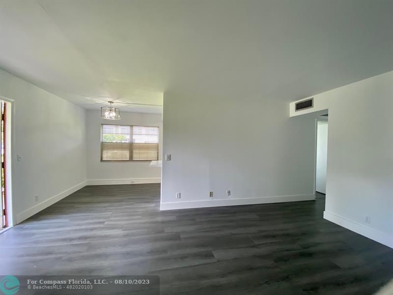 211 Mansfield East, Unit 211 Boca Raton, FL 33434 - Photo 10 of 14 an empty room with wooden floor and window