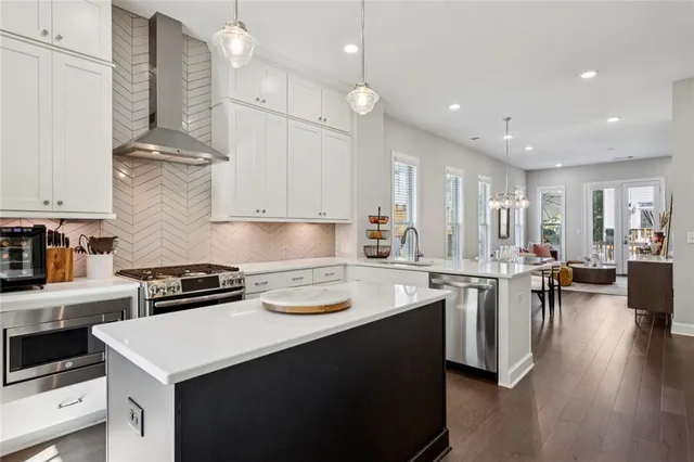 a kitchen with a stove a sink dishwasher and a refrigerator with wooden floor