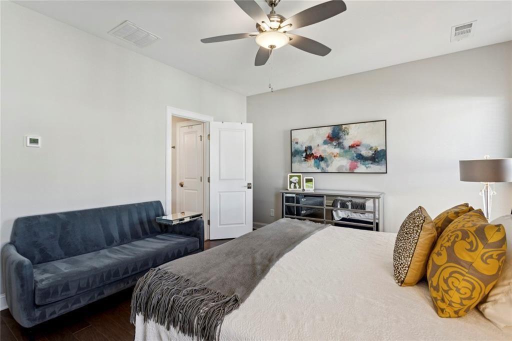 4219 Deming Circle Sandy Springs, GA 30342 - Photo 30 of 43 a spacious bedroom with a bed a couch and a chandelier