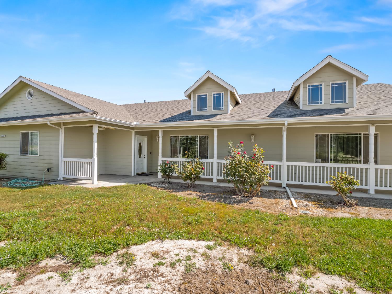 16389 Monreal Road Madera, CA 93636 - Photo 1 of 52 a front view of a house with a garden and porch