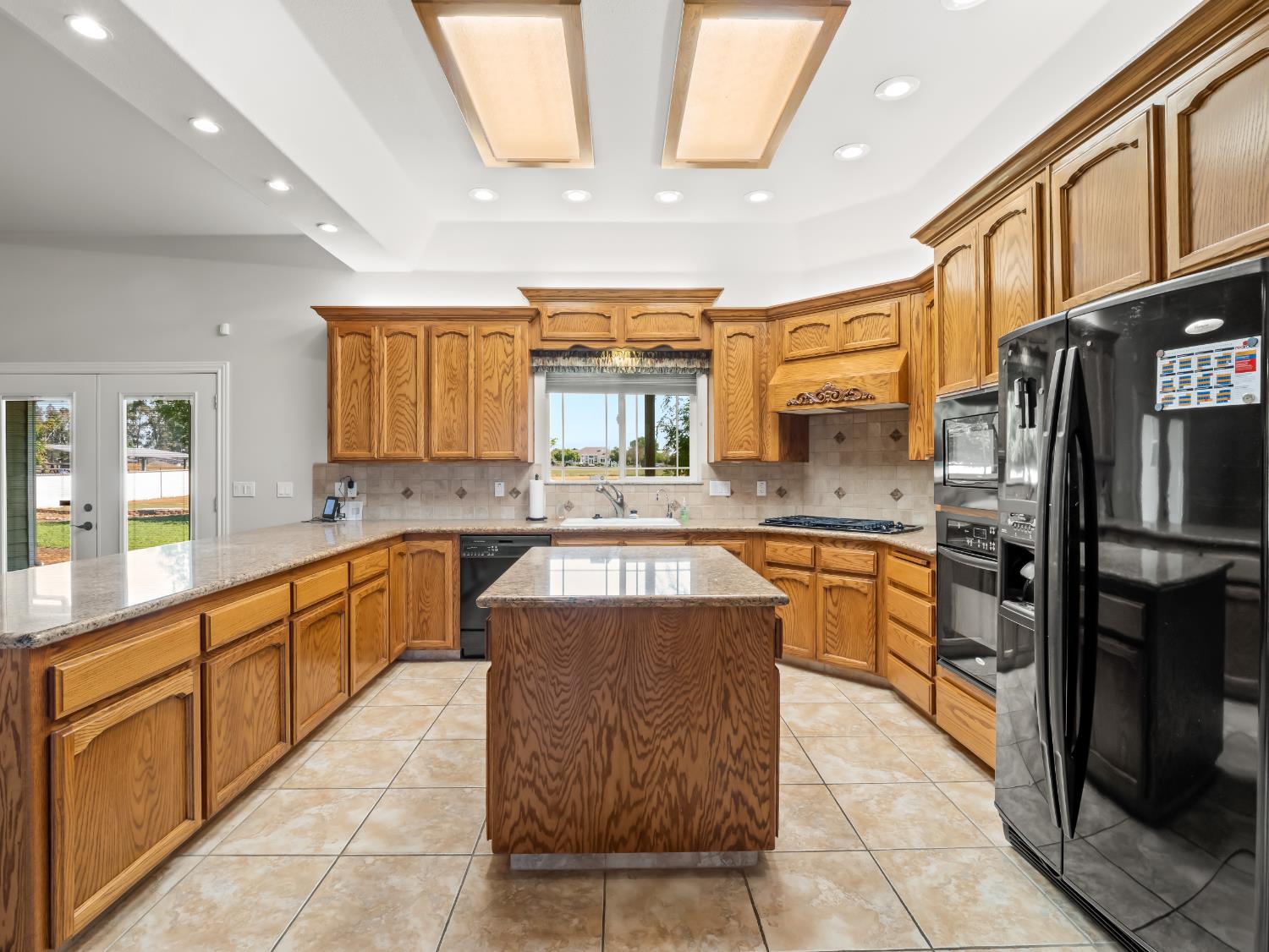 16389 Monreal Road Madera, CA 93636 - Photo 11 of 52 a large kitchen with stainless steel appliances kitchen island granite countertop a large counter top stainless steel appliances and cabinets