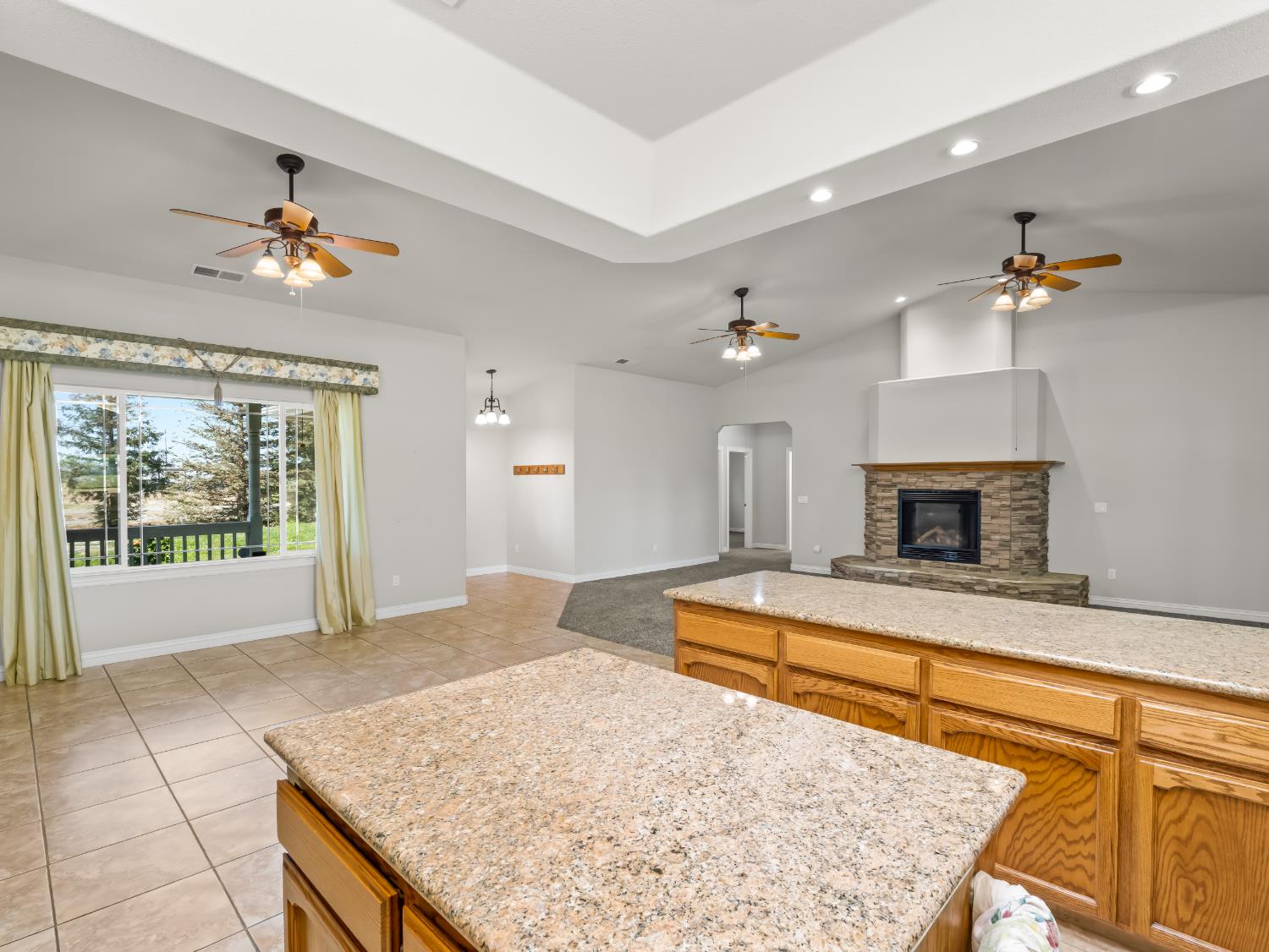 16389 Monreal Road Madera, CA 93636 - Photo 12 of 52 a living room with kitchen island granite countertop furniture and a fireplace