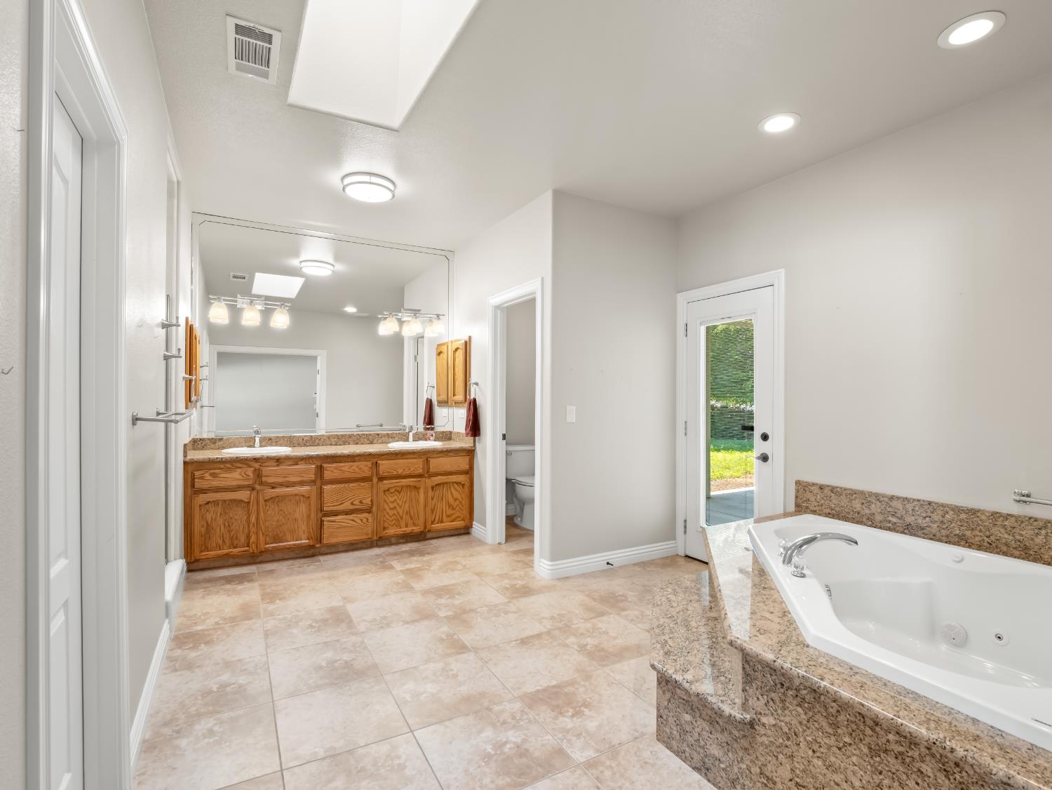 16389 Monreal Road Madera, CA 93636 - Photo 19 of 52 a bathroom with a granite countertop tub sink and mirror