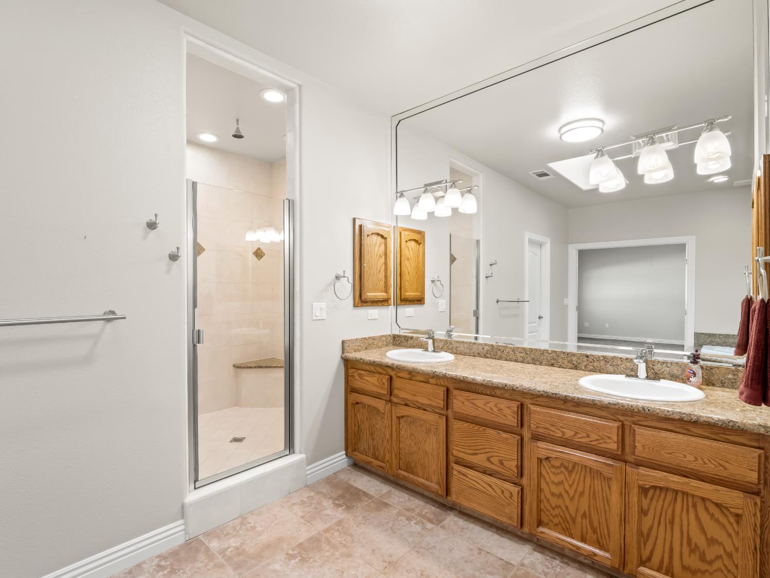 16389 Monreal Road Madera, CA 93636 - Photo 21 of 52 a bathroom with double vanity sink and a mirror