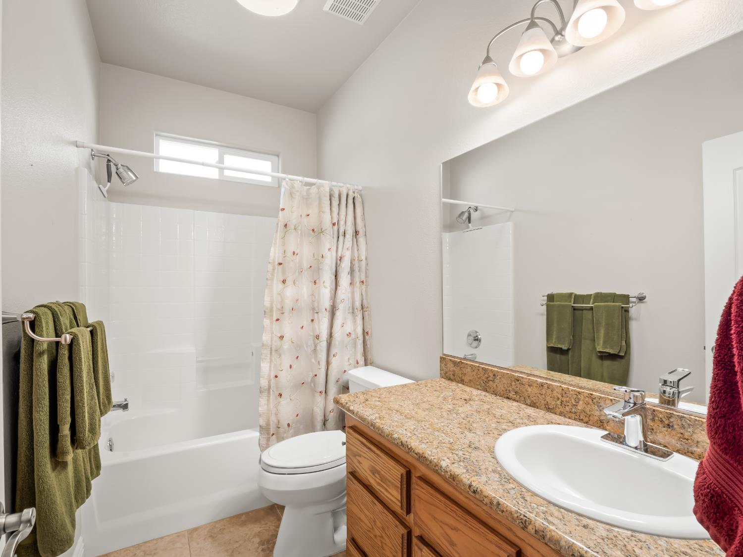 16389 Monreal Road Madera, CA 93636 - Photo 30 of 52 a bathroom with a granite countertop sink toilet and shower