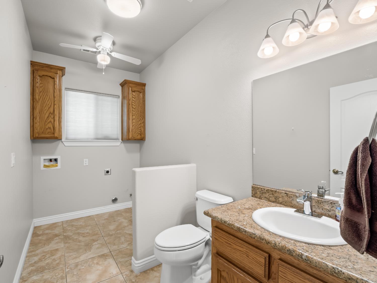 16389 Monreal Road Madera, CA 93636 - Photo 32 of 52 a bathroom with a granite countertop sink vanity mirror and toilet