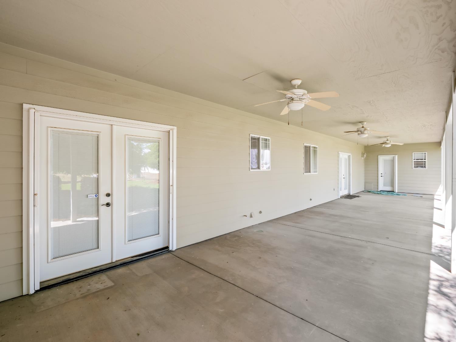 16389 Monreal Road Madera, CA 93636 - Photo 37 of 52 an empty room with chandelier fan and windows
