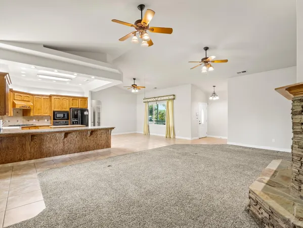 a view of kitchen with granite countertop cabinets and window