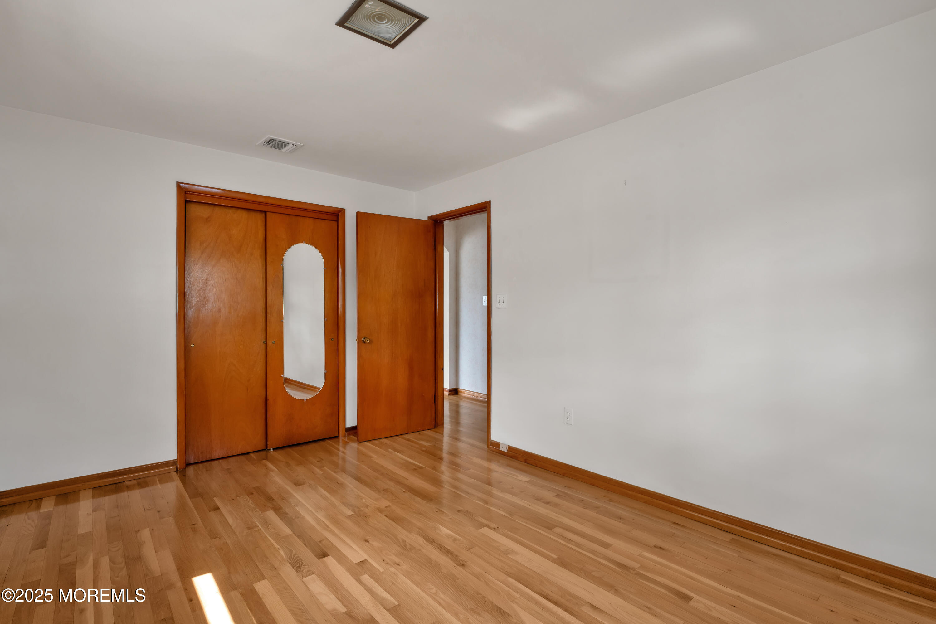 1215 Dorsett Dock Road Point Pleasant, NJ 08742 - Photo 11 of 16 a view of an empty room with wooden floor and a window