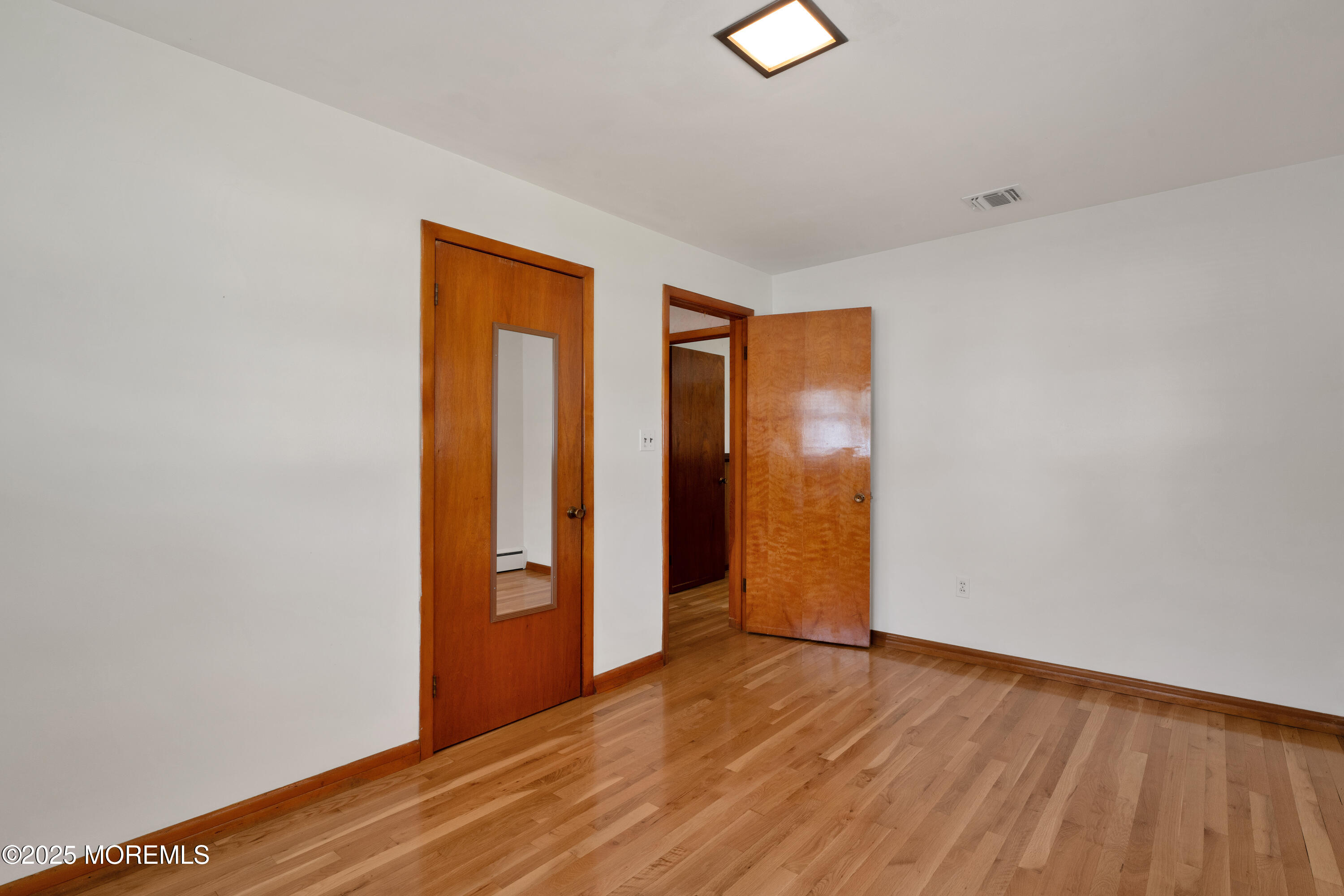 1215 Dorsett Dock Road Point Pleasant, NJ 08742 - Photo 14 of 16 a view of an empty room with wooden floor and closet
