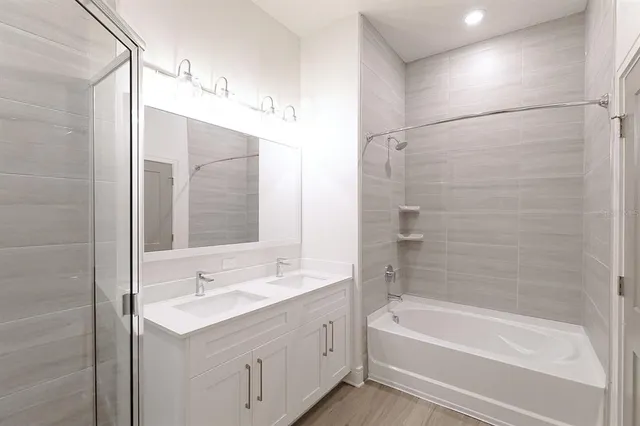 a bathroom with a tub sink shower and mirror