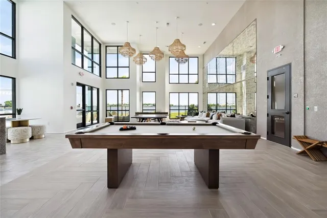 a dining hall with couches and potted plants with wooden floor