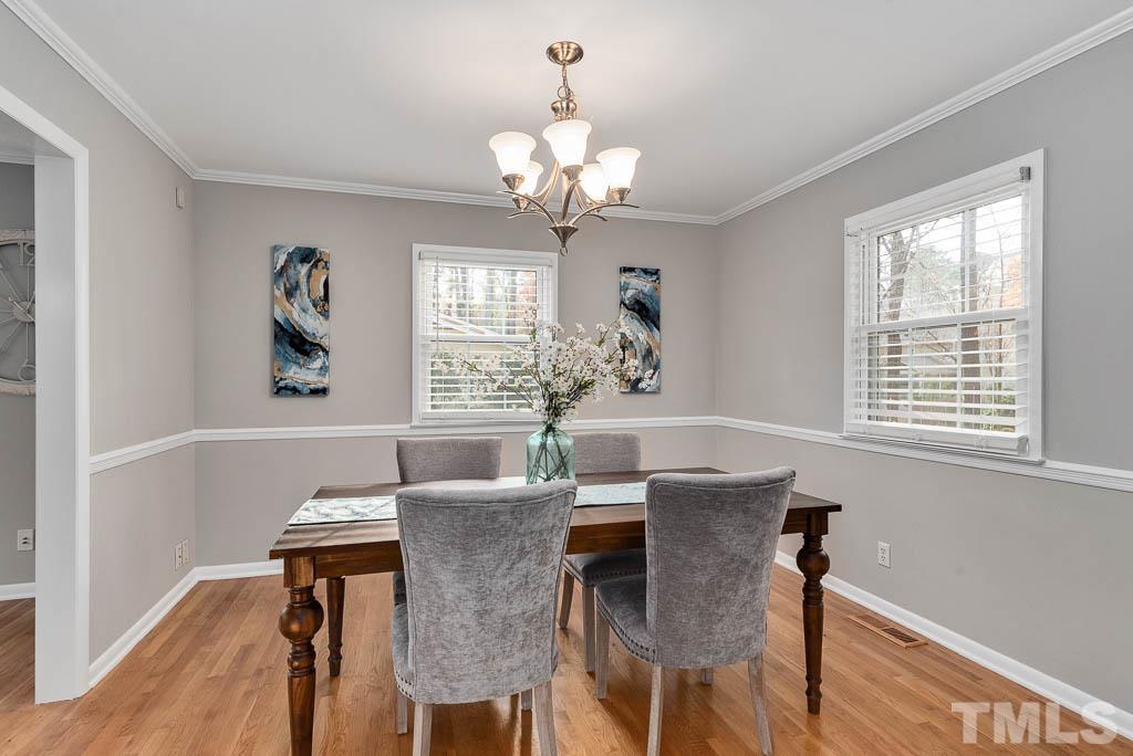 7405 Fiesta Way Raleigh, NC 27615 - Photo 8 of 38 a view of a dining room with furniture a chandelier and wooden floor