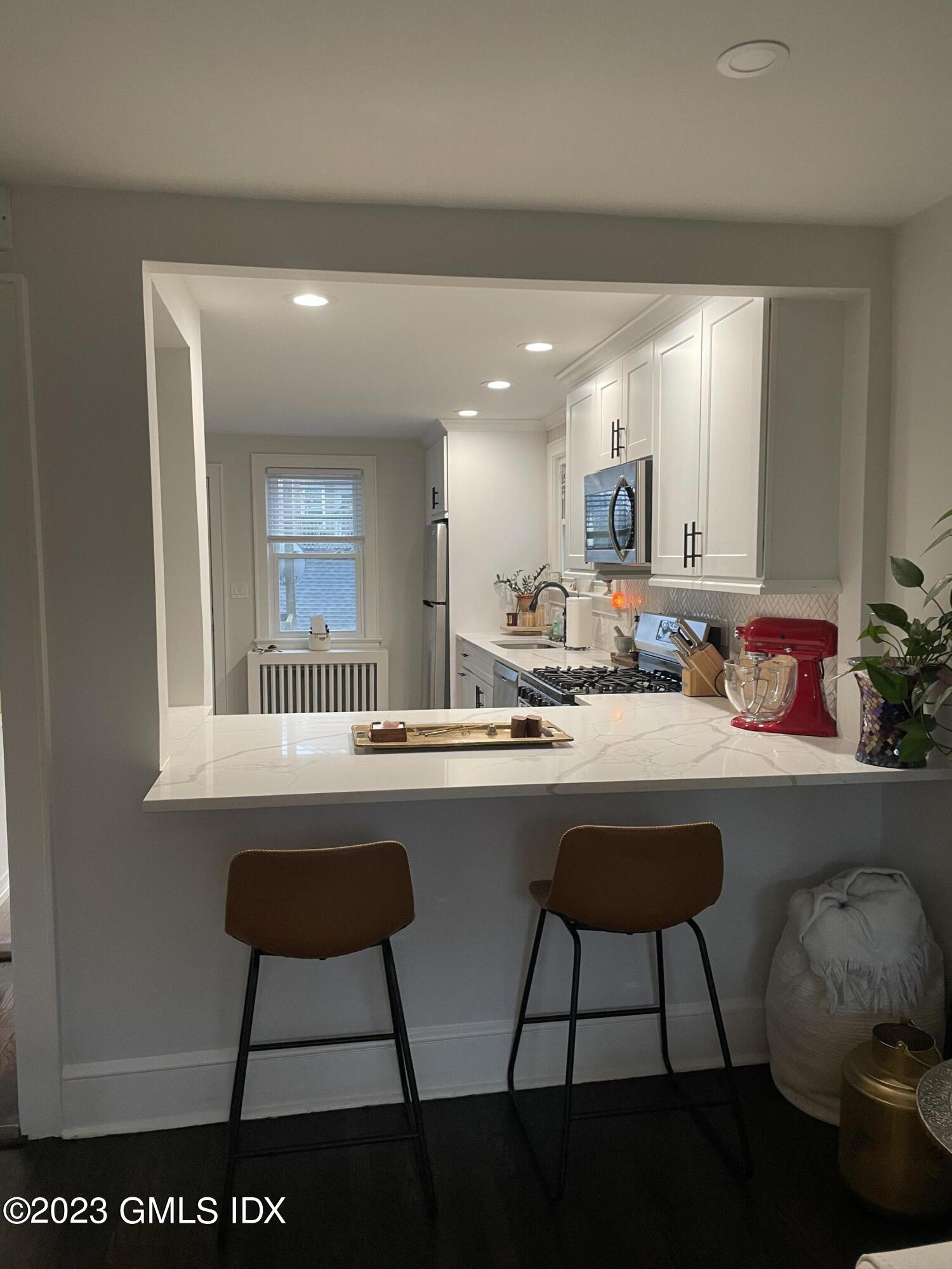 60 Weaver Street, Unit 2 Greenwich, CT 06831 - Photo 6 of 20 a kitchen with a sink and chairs